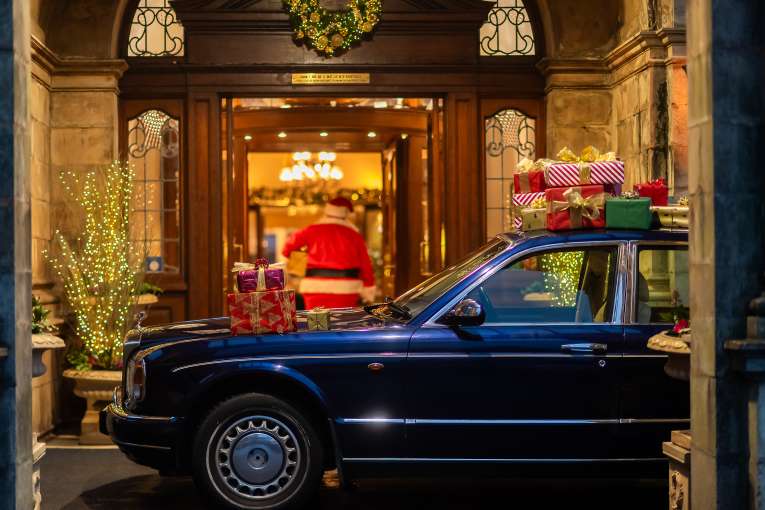 Rolls Royce Parked at Entrance and Santa Walking into the Victoria Hotel with Gifts