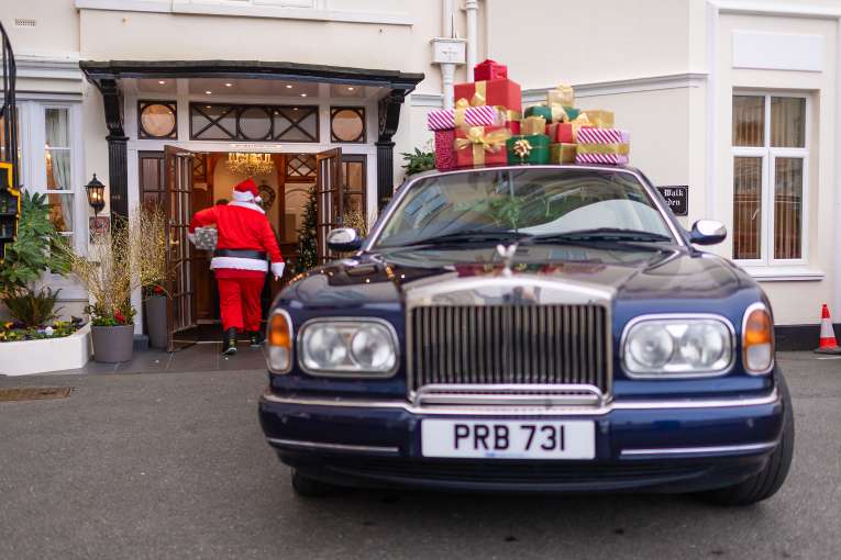 Santa Walking into Belmont Hotel with Presents 