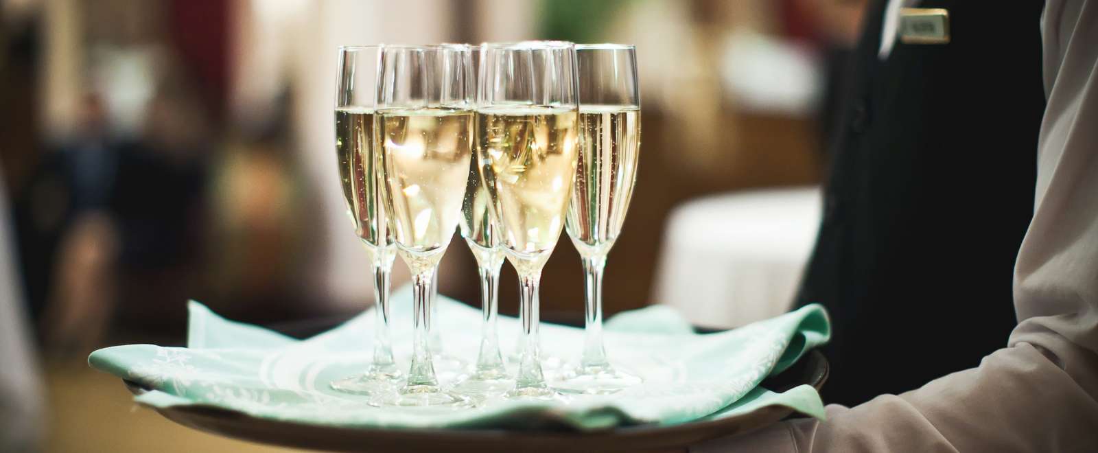 waiter carrying glasses of champagne on a tray