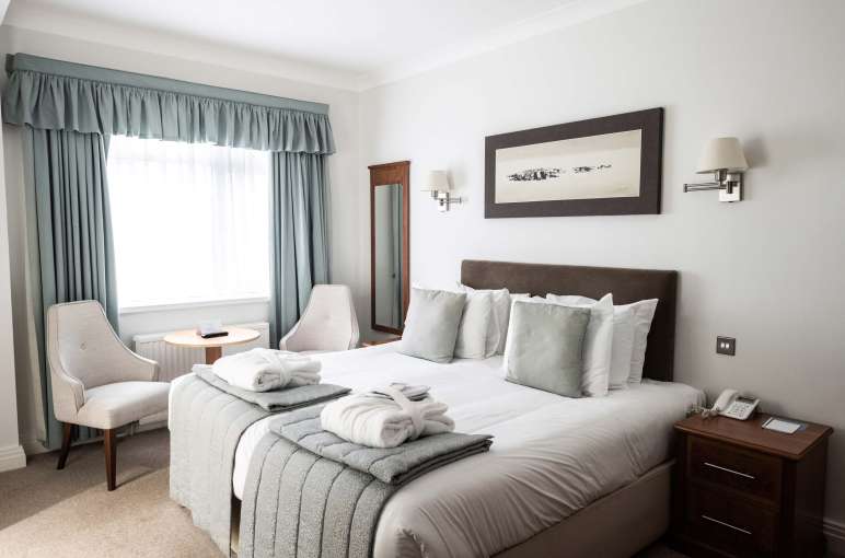 Saunton Sands Hotel Cosy Room Accommodation Bedroom with Seating Area and Dressing Gowns on Bed