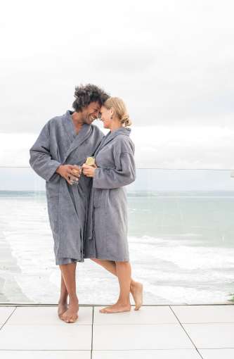 Saunton Sands couple on source spa balcony with sea in background drinking lemon water