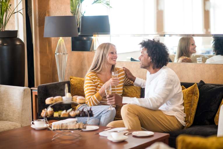 Saunton Sands couple sat on sofa in lounge with afternoon tea