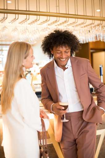 Saunton Sands couple stood at bar laughing drinking cocktails
