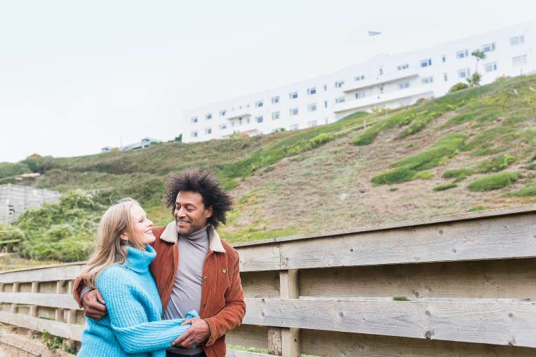 couple walking down from saunton sands hotel beach